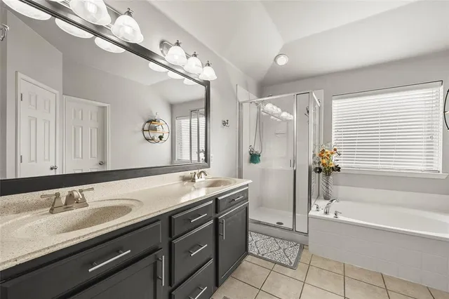 a bathroom with a tub a double vanity sink and mirror