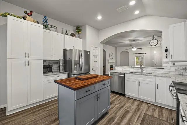 a kitchen with stainless steel appliances granite countertop refrigerator sink and stove