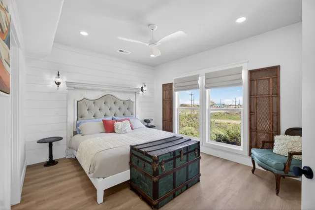 a bedroom with a bed and a view of bedroom with window