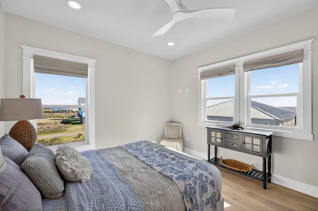 a bedroom with a bed a couch and dresser with wooden floor
