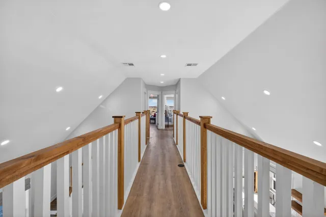 a view of a hallway with wooden floor and stairs