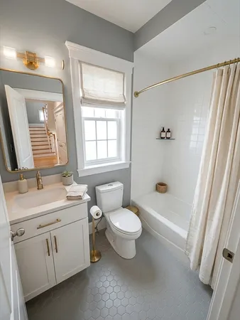 a bathroom with a toilet sink and mirror with bathtub