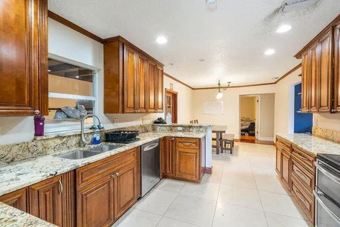 a kitchen with stainless steel appliances granite countertop wooden cabinets a oven and granite counter tops with a stove