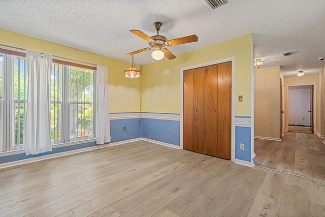 a view of an empty room with window and cabinet