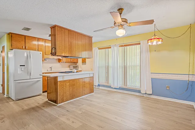 a kitchen with a refrigerator a stove top oven and a window