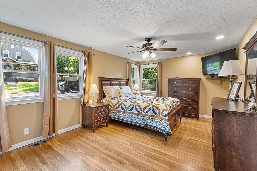 10 Truro Street Worcester, MA 01603 - Photo 16 of 32 a bedroom with a large bed a flat tv screen and dresser