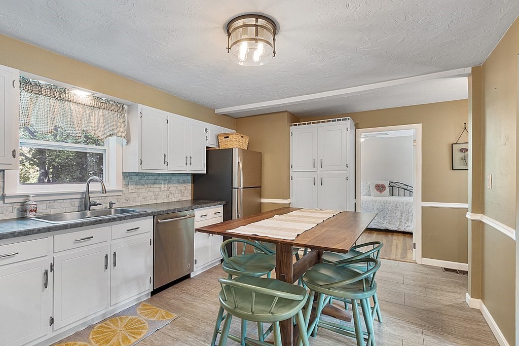 10 Truro Street Worcester, MA 01603 - Photo 7 of 32 a kitchen with a table chairs refrigerator and cabinets