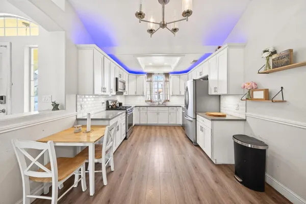 a large kitchen with kitchen island a large counter space a sink stainless steel appliances and cabinets
