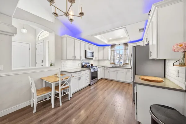 a kitchen with a sink cabinets and wooden floor