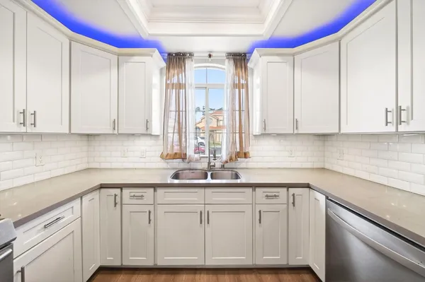 a kitchen with white cabinets and white appliances