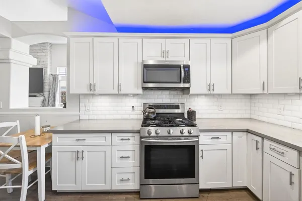 a kitchen with white cabinets stainless steel appliances and sink