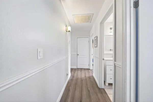a view of a hallway with wooden floor and staircase