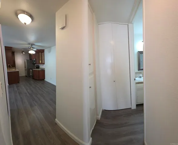 a view of a hallway with wooden floor and furniture