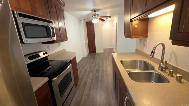 a kitchen with a sink a microwave a stove and refrigerator