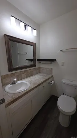 a bathroom with a toilet sink and mirror
