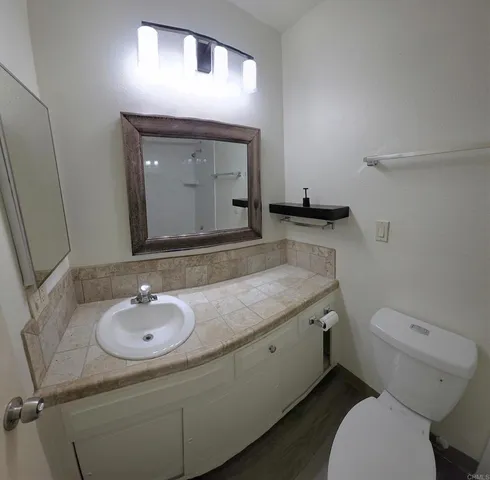 a bathroom with a toilet sink and mirror