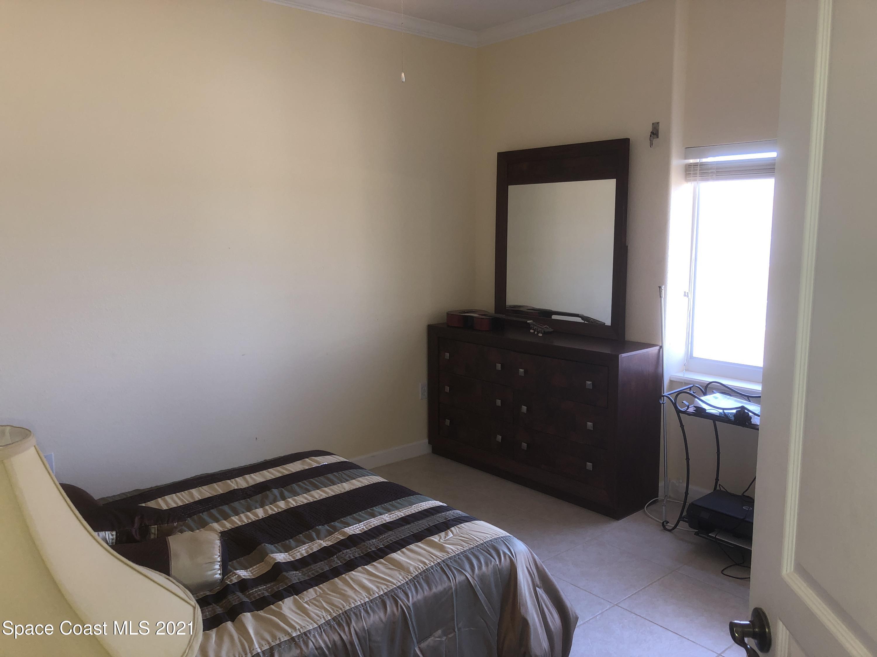 2075 Florida A1A, Unit 2705 Indian Harbour Beach, FL 32937 - Photo 19 of 30 a bedroom with a bed and a mirror