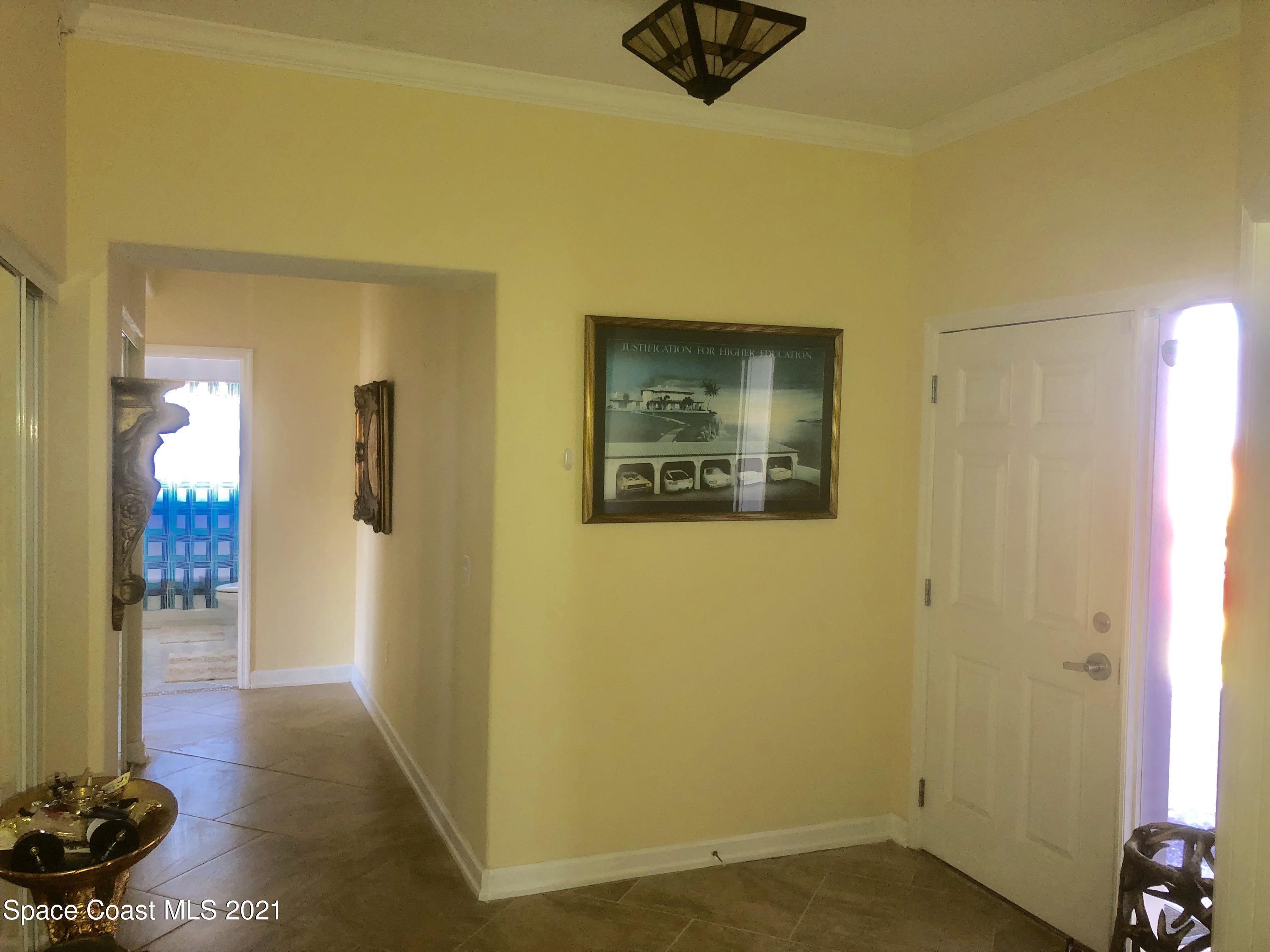 2075 Florida A1A, Unit 2705 Indian Harbour Beach, FL 32937 - Photo 9 of 30 a view of a hallway with wooden floor and a bookshelf