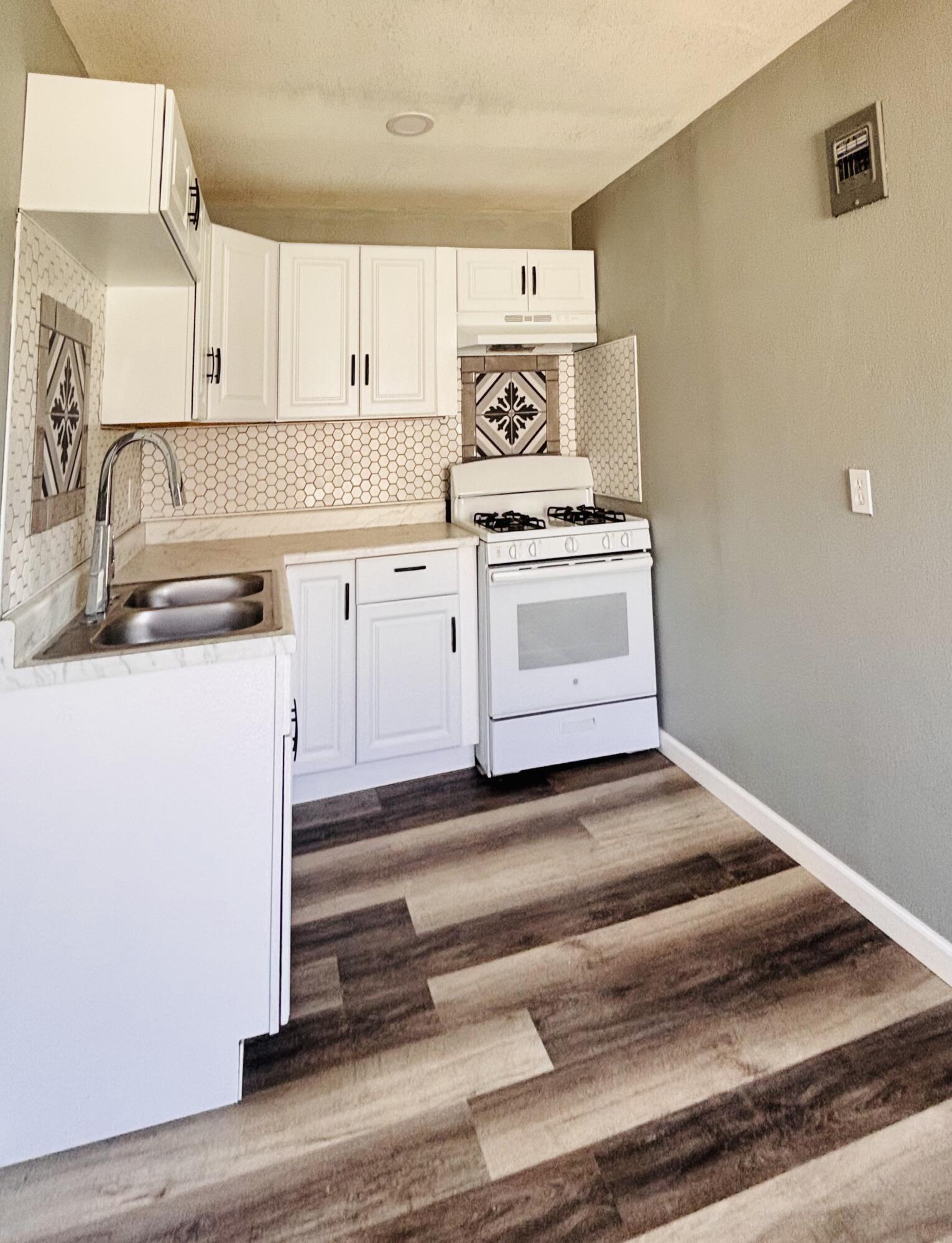 1108 41st Street Lubbock, TX 79412 - Photo 7 of 21 a kitchen with a stove cabinets and wooden floor