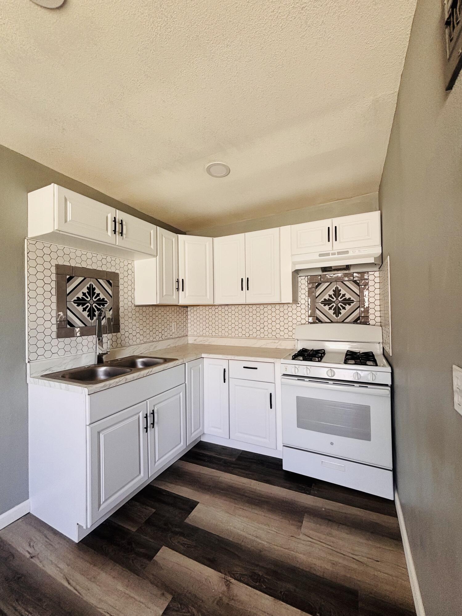 1108 41st Street Lubbock, TX 79412 - Photo 9 of 21 a kitchen with granite countertop a stove and cabinets
