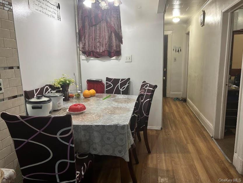 86-37 80th Street Queens, NY 11421 - Photo 2 of 5 Dining area featuring dark wood-style floors and baseboards