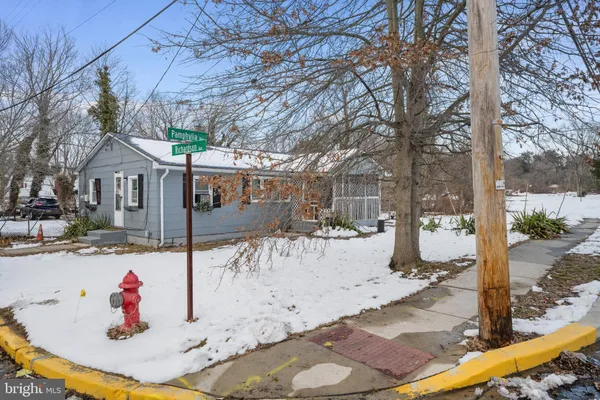 a view of a white house with snow on the side of the road