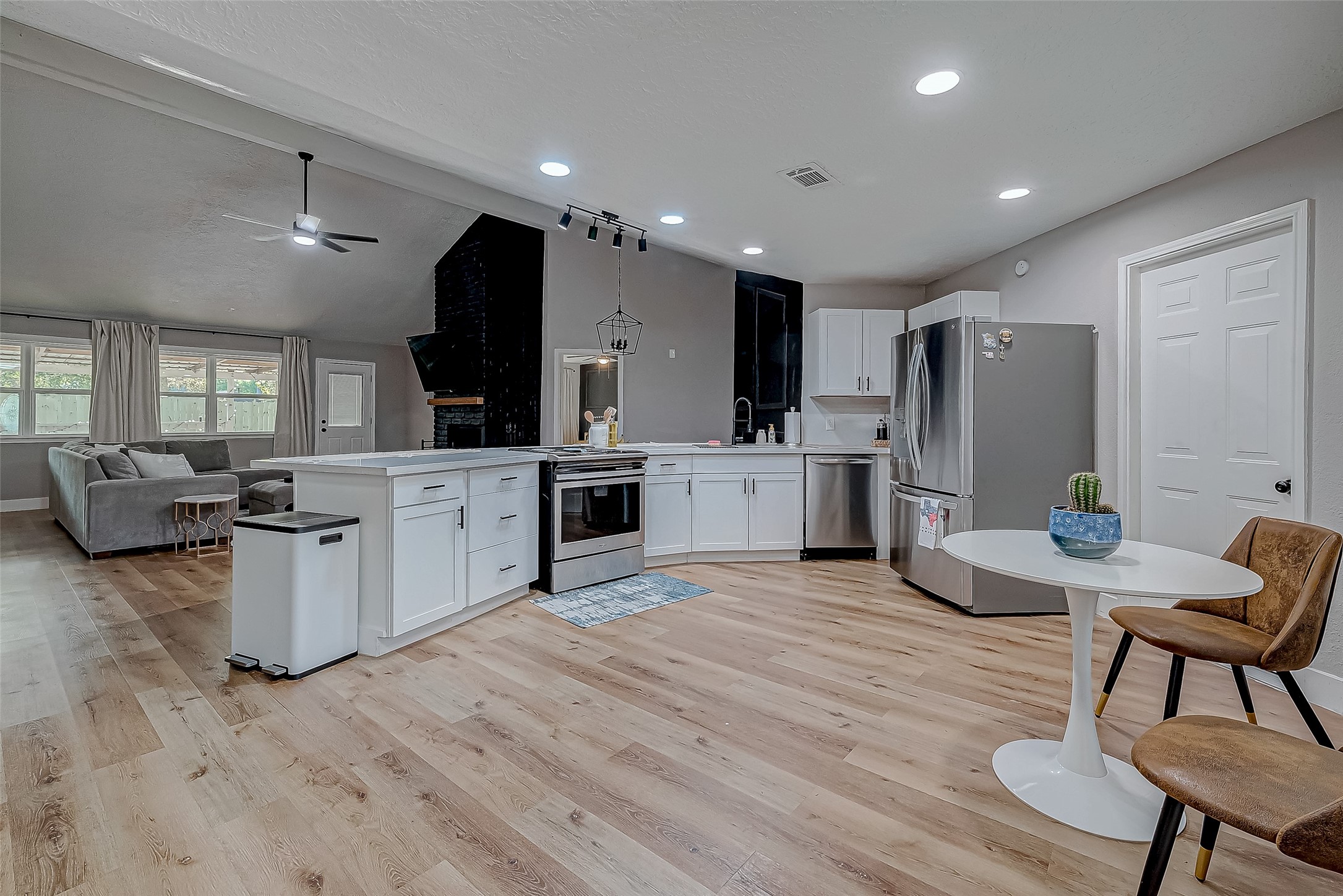 17431 Typhoon Way Crosby, TX 77532 - Photo 5 of 34 a large white kitchen with cabinets furniture and a wooden floor