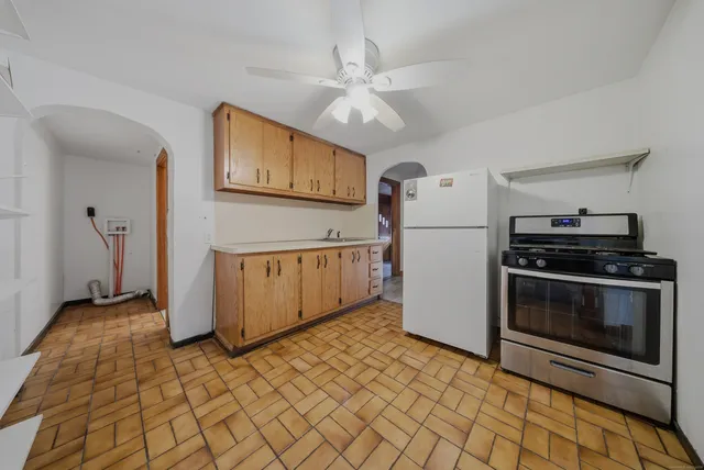 a kitchen with stainless steel appliances granite countertop a refrigerator a stove and a sink