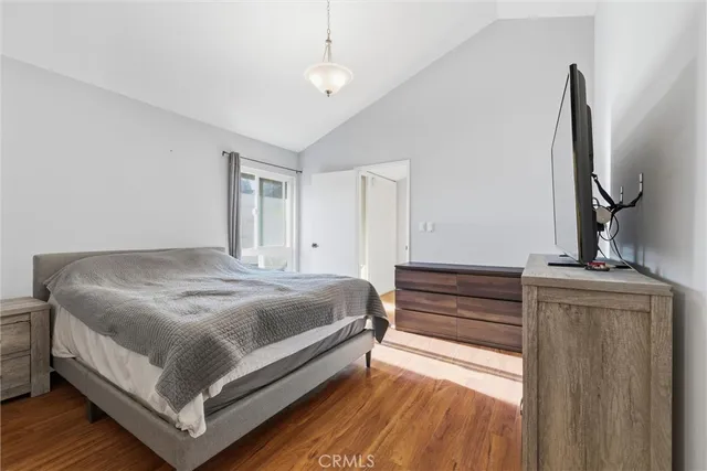 a bedroom with a bed and a flat tv screen on dresser