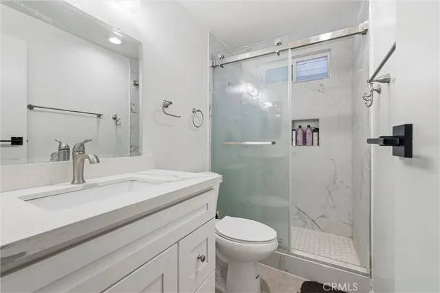 a bathroom with a sink a toilet and shower