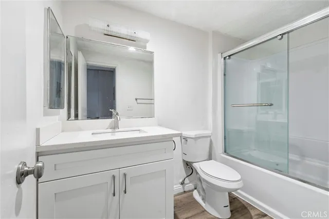 a bathroom with a sink toilet vanity and shower