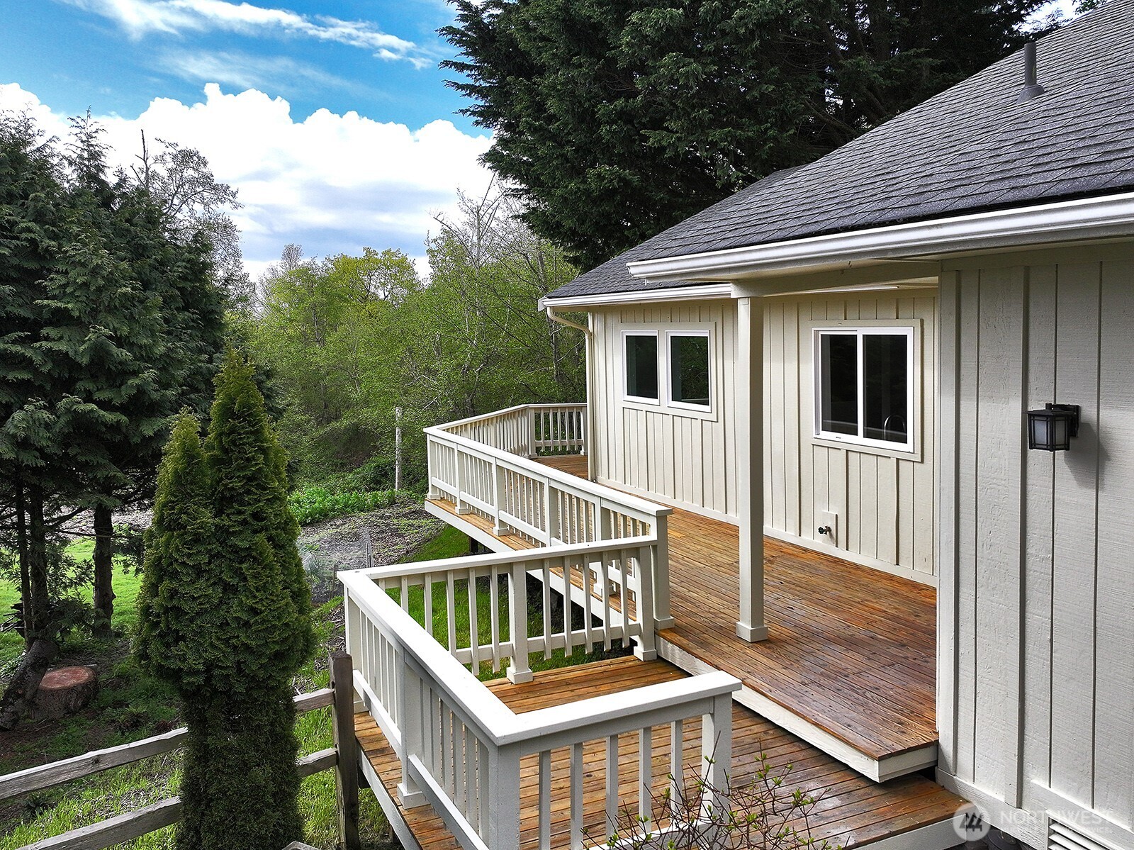 3760 Periwinkle Road Clinton, WA 98236 - Photo 5 of 34 a white house with a large window and wooden fence