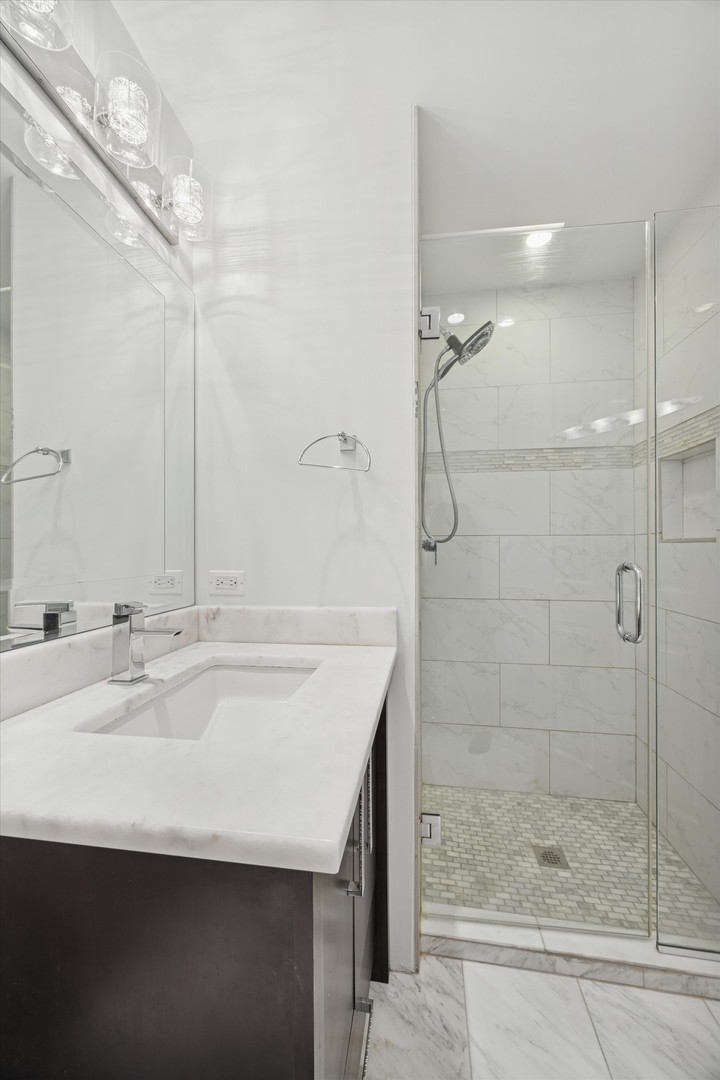 179 Foxborough Place Burr Ridge, IL 60527 - Photo 12 of 18 a bathroom with a shower sink and mirror