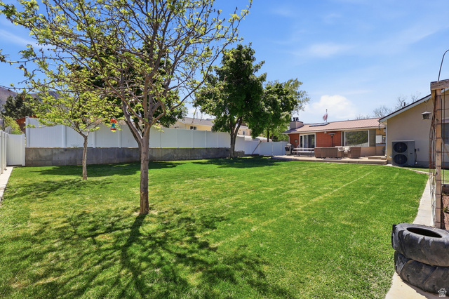 114 North Clark Lane Elk Ridge, UT 84651 - Photo 26 of 26 Expansive backyard featuring a manicured lawn, established trees, and a white privacy fence
