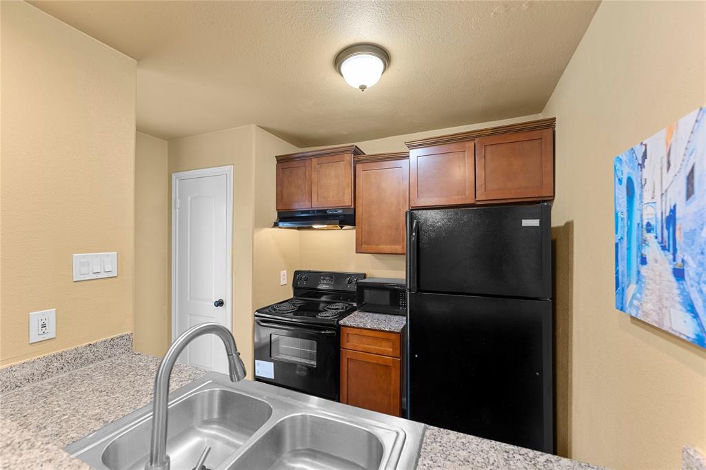 5516 Boca Raton Boulevard, Unit 310 Fort Worth, TX 76112 - Photo 6 of 19 a kitchen with a refrigerator stove and cabinets