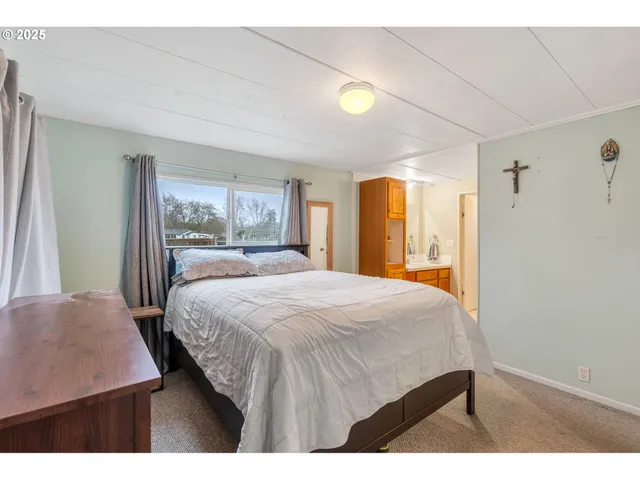 a bedroom with a bed and a dresser with mirror