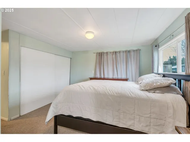 a bedroom with a bed and a large window