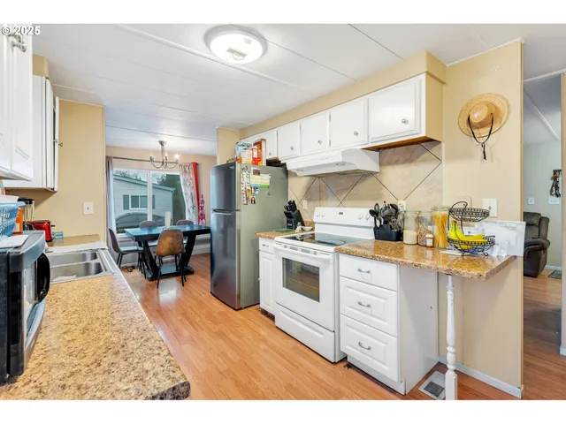 a kitchen filled with white cabinets and appliances