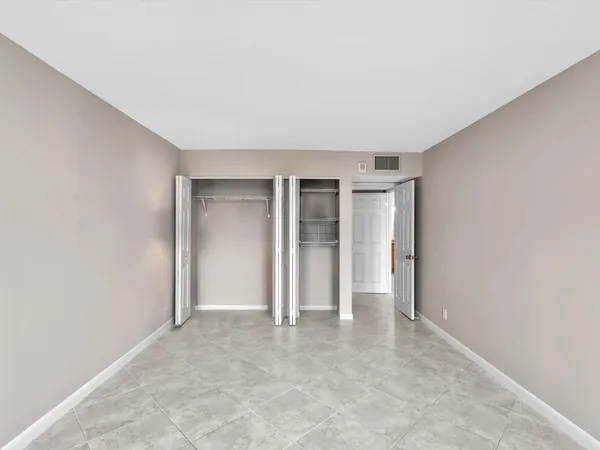 an empty room with closet and windows