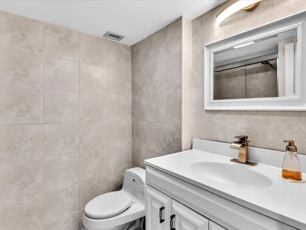 a bathroom with a sink a toilet and mirror