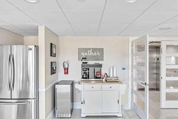 a kitchen with stainless steel appliances granite countertop a refrigerator a sink dishwasher a dining table and chairs with wooden floor