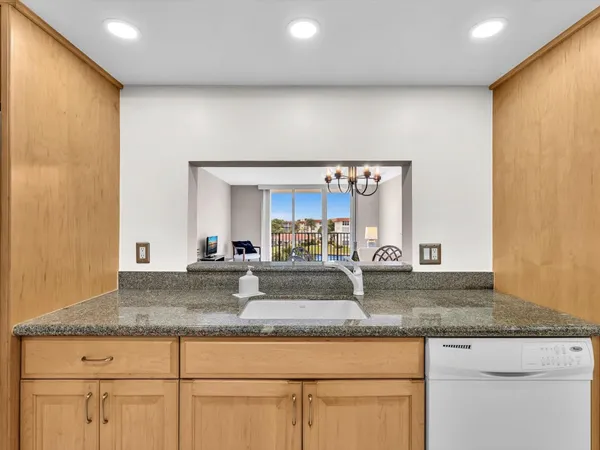 a kitchen with granite countertop stainless steel appliances a sink and a counter top