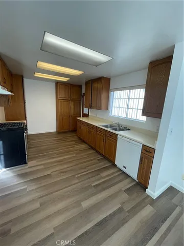 a large kitchen with wooden floors and stainless steel appliances