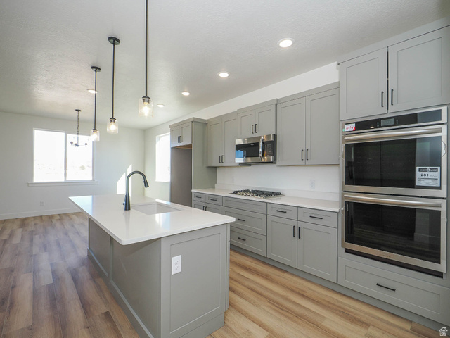 3938 North Wood Road Eagle Mountain, UT 84005 - Photo 13 of 55 Kitchen featuring stainless steel appliances, gray cabinetry, and an island with sink