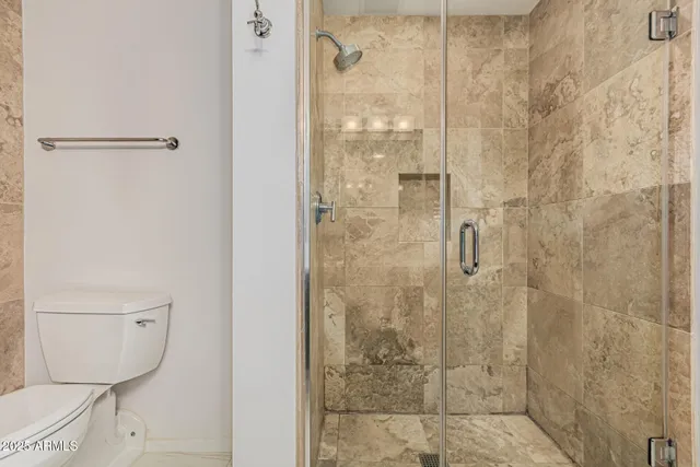 a bathroom with a toilet and a shower
