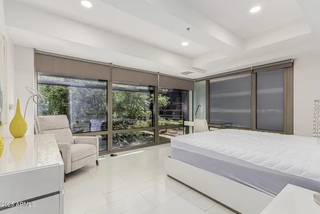 a bedroom with a bed and large glass window