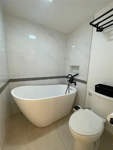 a white bath tub sitting next to a toilet