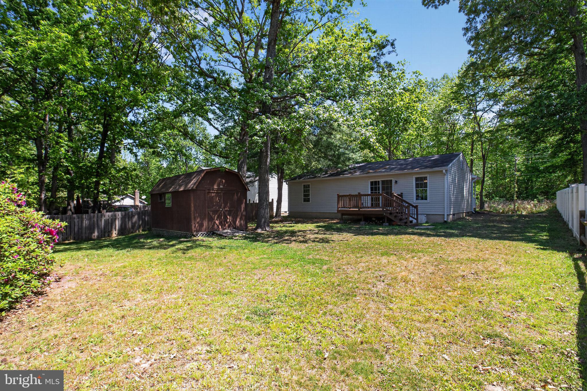 11789 Little Cove Point Road Lusby, MD 20657 - Photo 4 of 16 a view of a house with a yard and large tree