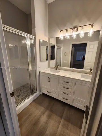 a bathroom with a double vanity sink mirror and shower