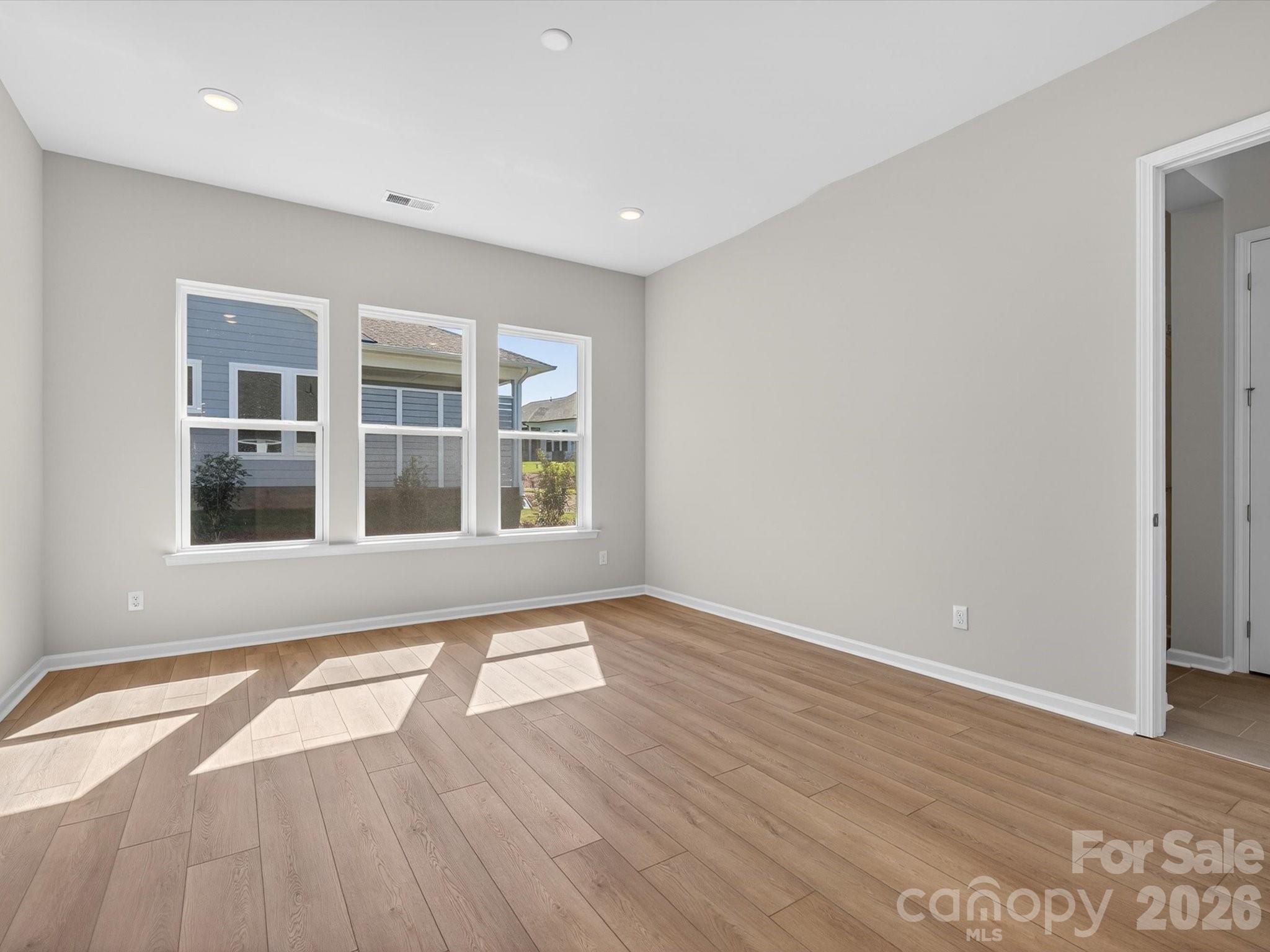 1007 Meander Lane Waxhaw, NC 28173 - Photo 12 of 35 a view of an empty room with wooden floor and a window